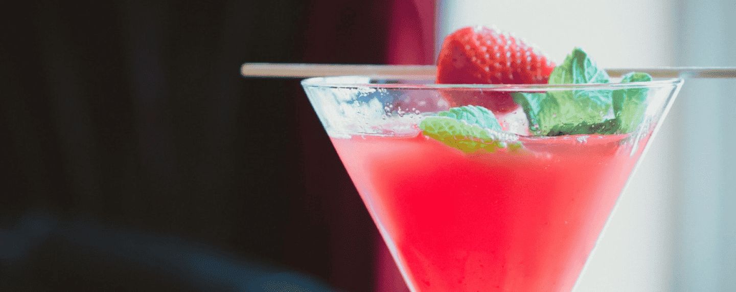 strawberry daiquiri cocktail with basil and a strawberry as garnish