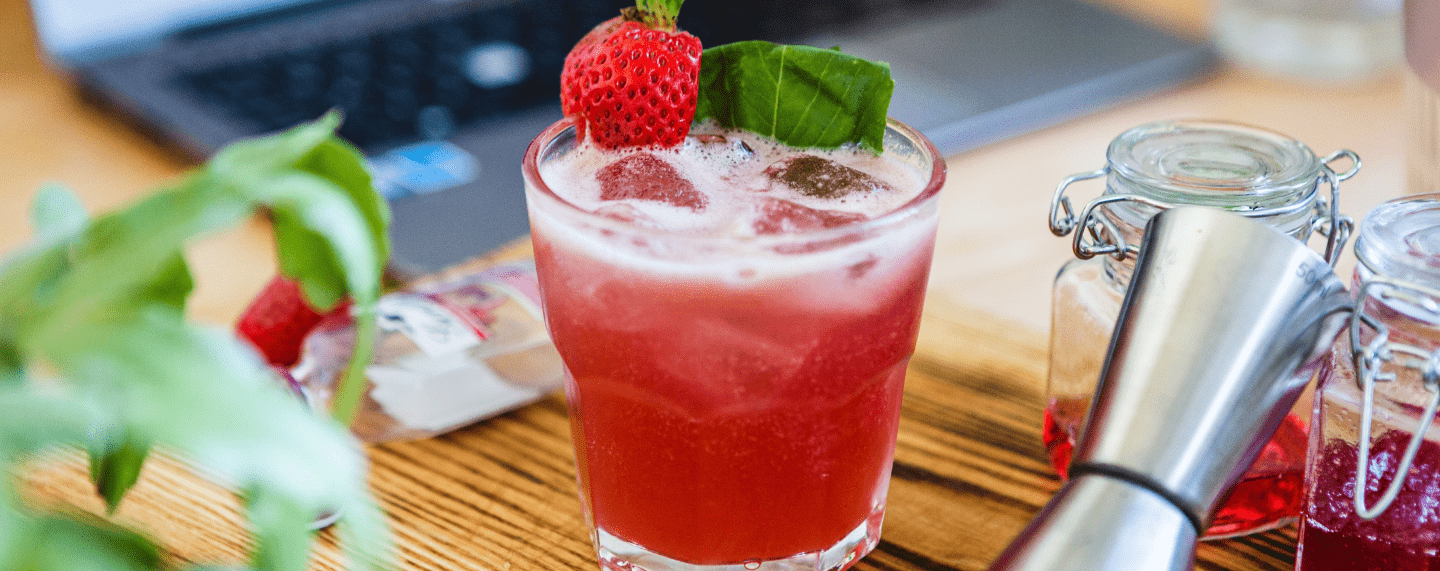 Valentine's Daiquiri on a desk with a laptop in the background